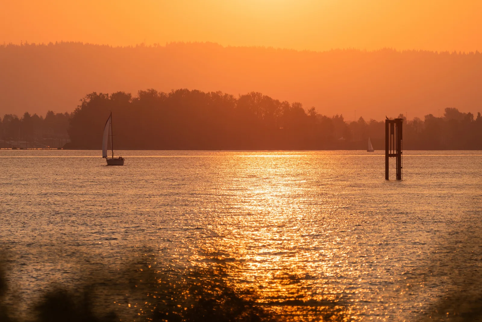 Sunset view of a wide river and sailboat near the Clark Regional Wastewater District, showing local waterways protected by infrastructure upgrades.